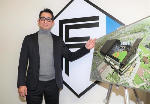 2023年3月に開業する新球場「エスコンフィールド北海道」のパネルを前に笑顔の日本ハム前沢取締役事業統轄本部長（撮影・黒川智章）